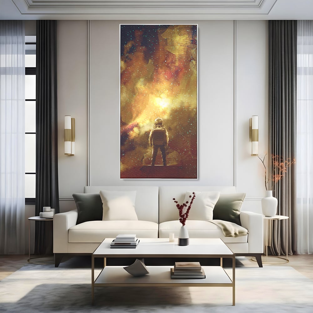 Tablou canvas cu ilustratie cu astronaut privind stelele, in rama de aluminiu argintiu, pe perete intr-un living